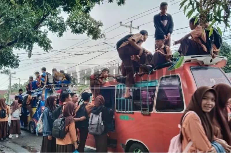 Pelajar naik di atap angkot (foto: Timothy Saragi/Parboaboa)
