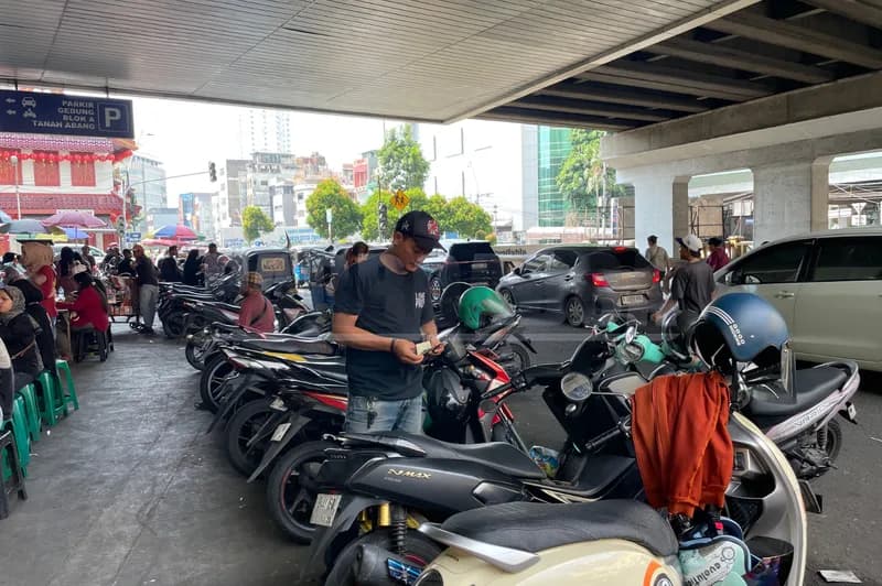 Seorang jukir liar di Pintu Timur Blok B Pasar Tanah Abang (Foto: PARBOABOA/Defri Ngo)